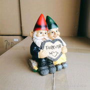 Garden gnome couple statue holding a heart that says 'FOREVER', perfect for garden decor.