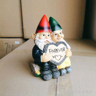 Garden gnome couple statue holding a heart that says 'FOREVER', perfect for garden decor.